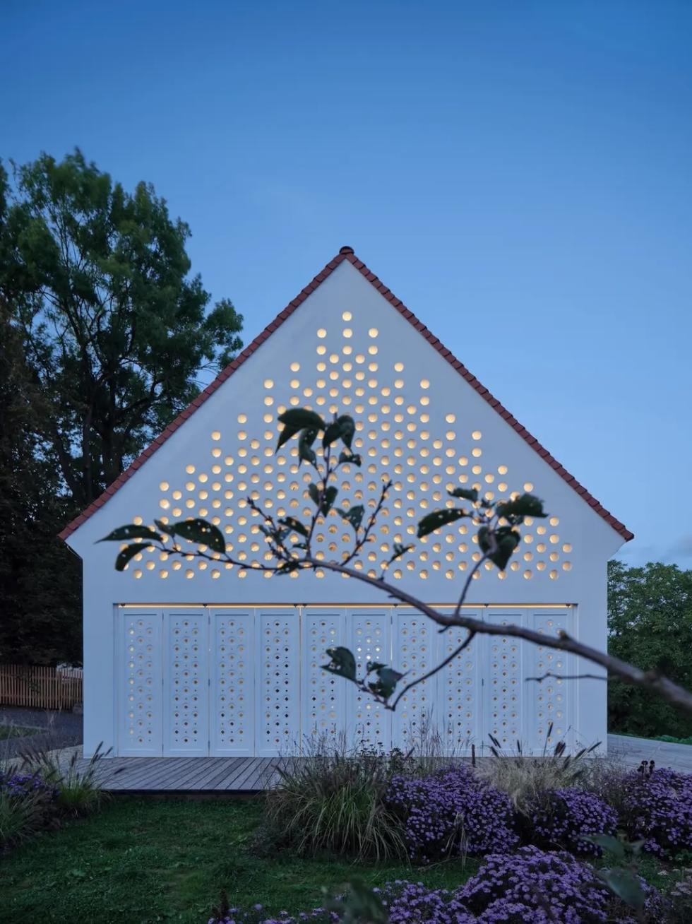 Egy nyeregtetős otthon, mely perforált falai a napszakkal változó fényjátékot teremtenek a szobákban