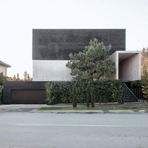 Beton és fekete tégla kombinációja adja a szlovén otthon külső esztétikáját