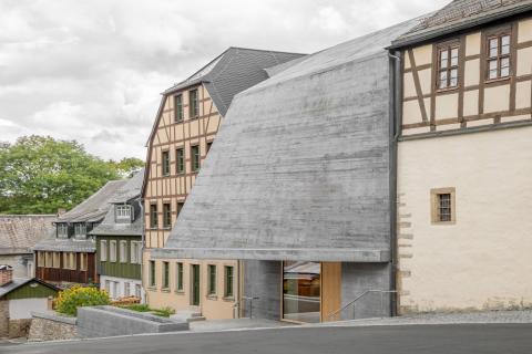 Szoborszerű betonház a hagyományos házak között