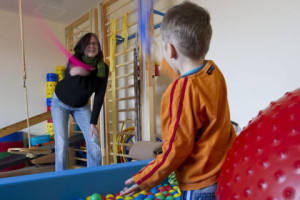 Egy terapeuta játszik egy autista kisgyerekkel