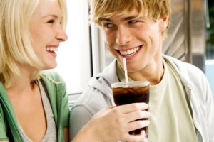 Young couple sharing a cola drink in a diner