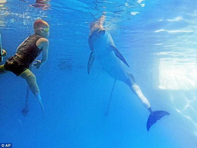 Mesterséges végtagokkal úszik a delfinekkel egy kisfiú
