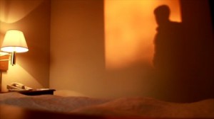 stock-footage-warm-late-afternoon-sunlight-pouring-into-a-hotel-room-casts-a-shadow-on-the-wall-of-a-man-pacing