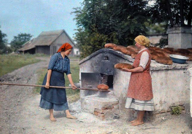 Two peasant women bake bread with an old-fashioned stove