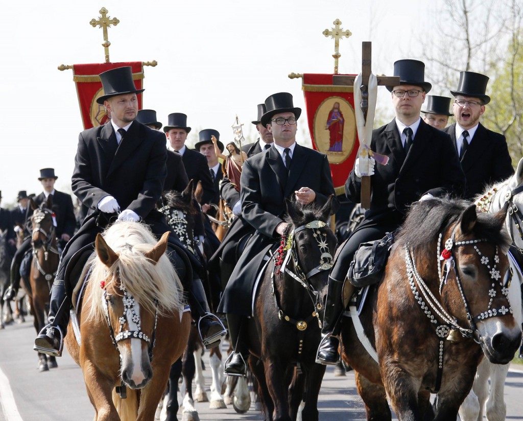 Noak and Wessela, Sorbs of the German Slavic minority, sing religious songs as they ride horses during a ceremonial parade in the village of Wittichenau