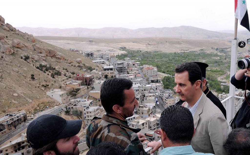 Syrian President Bashar al-Assad (R) speaks to a soldier during his visit to Maaloula