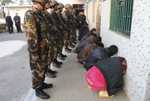 Paramilitary policemen guard suspects during a raid where three tonnes of crystal meth were seized at Boshe village, Lufeng
