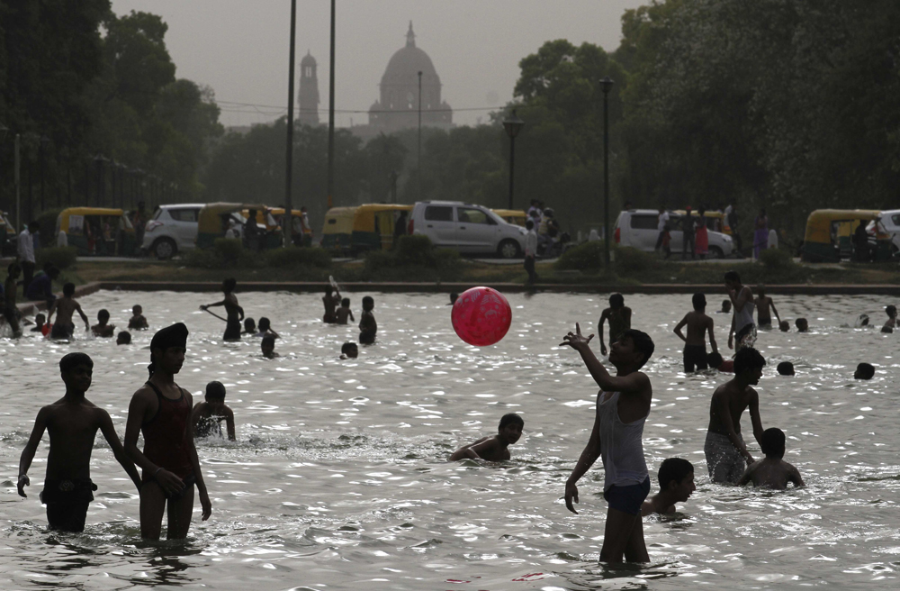 NEW DELHI, INDIA - MAY 24: Children enjoying at India Gate water pond during a hot weather as Delhi/NCR experienced yet another scorching day, on May 24, 2015 in New Delhi, India. The national capital sizzling today as heat wave-like conditions prevailed across the city with mercury hovering above 44.7 degree Celsius, making life tough for the Delhiites. (Photo by Virendra Singh Gosain/Hindustan Times via Getty Images)
