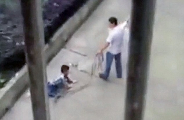 Pic shows: The father ticking off his son on a rope around his neck. A video has gone viral showing a father angrily dragging his son by a rope around his neck for several metres because his son was allegedly misbehaving and refused to study. The angry father was filmed by a local in Jinhua City, east China’s Zhejiang Province, when he forced his 10-year-old son out of his car by a rope and dragged him dozens of metres to their home. The boy can be seen crying and screaming as his father says: "I might as well treat you like a dog". The video had been shot by local Chan Fu who said: "I heard a child screaming and when I looked I saw the man trying to drag the child out of the car and he was clearly refusing to go. I grabbed my telephone and started filming it because I wanted to give it to the police." She had then also uploaded it online where it quickly went viral. According to the father, who was later approached by police, he had lost his temper because his son was out playing when he should have been studying. He apologised to authorities and admitted that his methods were inappropriate. He will not charged by police but has received a stern warning not to repeat the action the action. (ends)