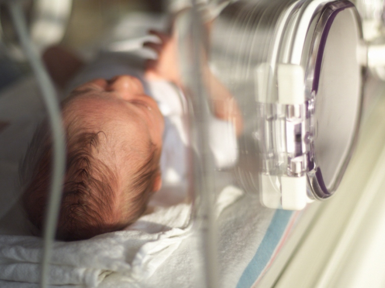 close up of a caucasain newborn baby in intensive care laying in an incubator