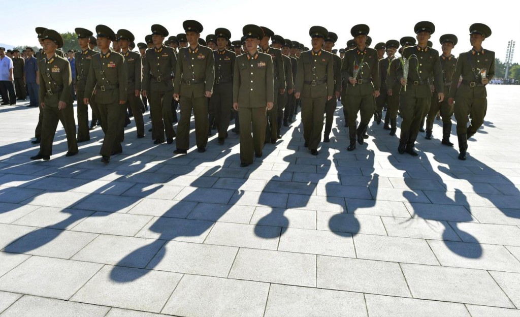 North Korean soldiers walk towards bronze statues of North Korea's late founder Kim Il Sung and late leader Kim Jong Il at Mansudae in Pyongyang