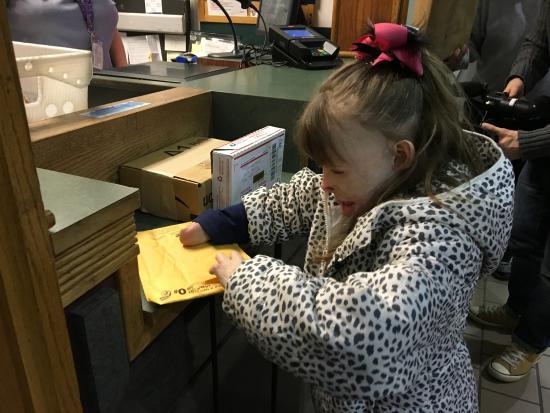 CORRECTS YEAR TO 2015, NOT 2013 - Safyre Terry, 8, opens a gift Wednesday, Dec. 9, 2015, at a post office near her home in Rotterdam, N.Y. Safyre, who lost her father and three younger siblings and was burned over 75 percent of her body in a May 2013 house fire, has been receiving cards and gifts from across the country since her custodial aunt posted a photo of her on Facebook with a message saying she’d like to get cards for a Christmas tree display stand. The post has been shared tens of thousands of times, and a crowd funding site has generated more than $177,000 for the family. (AP Photo/Mary Esch)