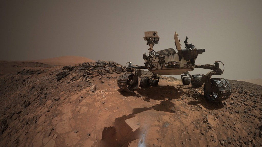 Szkafanderes ember tartja karban a Curiosity rover marsjárót