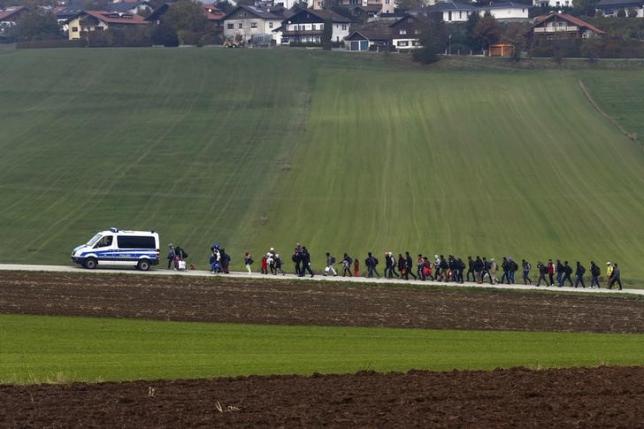 Immigrants are escorted by German police to a registration centre, after crossing the Austrian-German border in Wegscheid near Passau, Germany, October 20, 2015. REUTERS/Michael Dalder