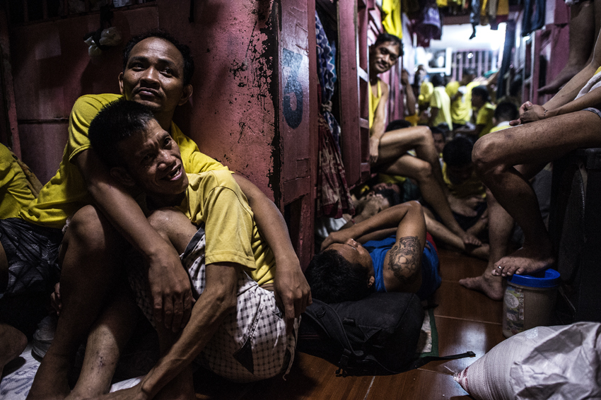 Inmates rest in their sleeping quarters inside the Quezon City jail at night in Manila in this picture taken on July 18, 2016. There are 3,800 inmates at the jail, which was built six decades ago to house 800, and they engage in a relentless contest for space. Men take turns to sleep on the cracked cement floor of an open-air basketball court, the steps of staircases, underneath beds and hammocks made out of old blankets. / AFP PHOTO / NOEL CELIS / TO GO WITH AFP STORY: Philippines-politics-crime-jails, FOCUS by Ayee Macaraig