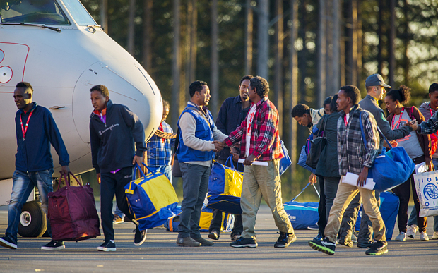 Eritrean asylum seekers arrive by an Italian Financial police aircraft to Lulea Airport, Kallax northern Sweden, Friday, Oct. 9, 2015. Italy bid farewell Friday to 19 Eritreans ó the first of an estimated 160,000 refugees to be resettled throughout Europe as part of a new EU redistribution program to move asylum-seekers out of hard-hit front-line countries. Bundled up in flannel shirts and jackets to prepare for their new lives in Sweden they landed in Lulea, just south of the Arctic Circle. Swedish officials now must register the refugees and begin processing their asylum requests. Sweden's immigration agency said the 14 men and five women, who ranged from 25 to 40 years old, were selected because they have a chance of being granted asylum and have family or other connections to Sweden. (Robert Nyholm/TT via AP) SWEDEN OUT